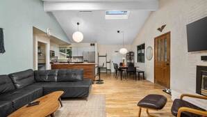 Un salon moderne avec un canapé en cuir noir, une table basse en bois et une cheminée.