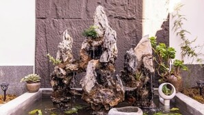 Jardín de rocas con un elemento acuático, que incluye un pequeño estanque y una cascada.