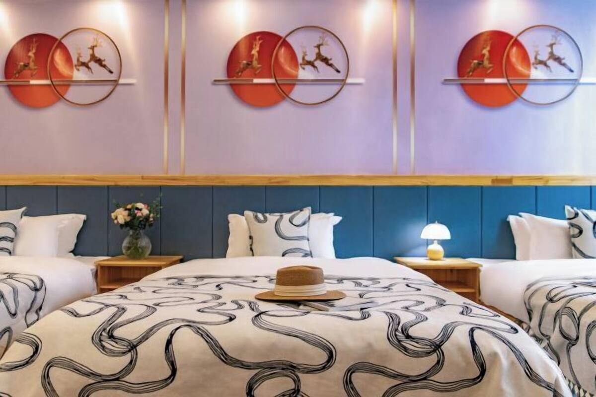A hotel room with a large bed, two bedside tables, and a wall-mounted artwork of deer.