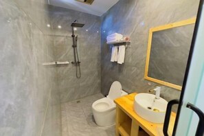 A modern bathroom with a marble wall, a shower, a toilet, and a vanity with a sink and mirror. - Lijiang Yihe Light Luxury Homestay (Lijiang Ancient City South Branch) (Lijiang)