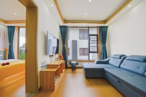 A modern hotel room with a large bed, a sofa, a TV, and a balcony with curtains. - Lijiang Yihe Light Luxury Homestay (Lijiang Ancient City South Branch) (Lijiang)