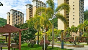 A residential complex with high-rise buildings, a central garden with palm trees, and a gazebo. - Coconut Maple Home Apartment (Wuzhishan)