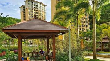 A gazebo in a park with a building in the background.