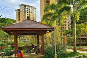 A gazebo in a park with a building in the background. - Coconut Maple Home Apartment (Wuzhishan)
