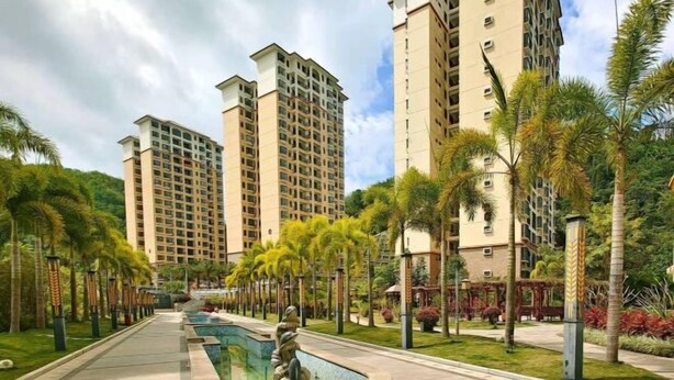 A residential area with high-rise apartment buildings, a central pathway, and a decorative water feature. - Coconut Maple Home Apartment (Wuzhishan)