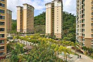 A residential complex with high-rise buildings, a landscaped garden area, and a pool. - Coconut Maple Home Apartment (Wuzhishan)