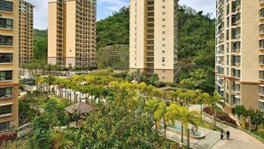 A residential complex with high-rise buildings, a central courtyard with palm trees, and a small pool area. - Coconut Maple Home Apartment (Wuzhishan)