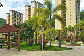A residential area with high-rise buildings, a park with benches, and a gazebo. - Coconut Maple Home Apartment (Wuzhishan)