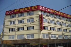 A multi-story building with signage indicating it is a business center and a TV broadcasting station. - Shunda Business Inn (Guangde)
