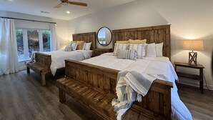 Ein Schlafzimmer mit zwei Betten, einem Deckenventilator, einem großen Spiegel und einem Fenster mit Vorhängen.