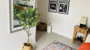 A room with a large mirror, a potted plant, a small table with a lamp, and a bed. - Date me ,Top Location , Close Beach  (Greenacres)