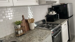 A kitchen with white cabinets, a black microwave, stainless steel appliances, and a granite countertop. - Date me ,Top Location , Close Beach  (Greenacres)