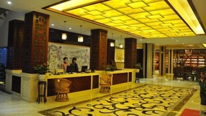 A hotel lobby with a reception desk, seating area, and a patterned floor. - Chaxiang Hotel (Ning'er)