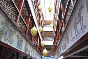 Un pasillo con elementos arquitectónicos tradicionales, como vigas de madera y paneles decorativos.