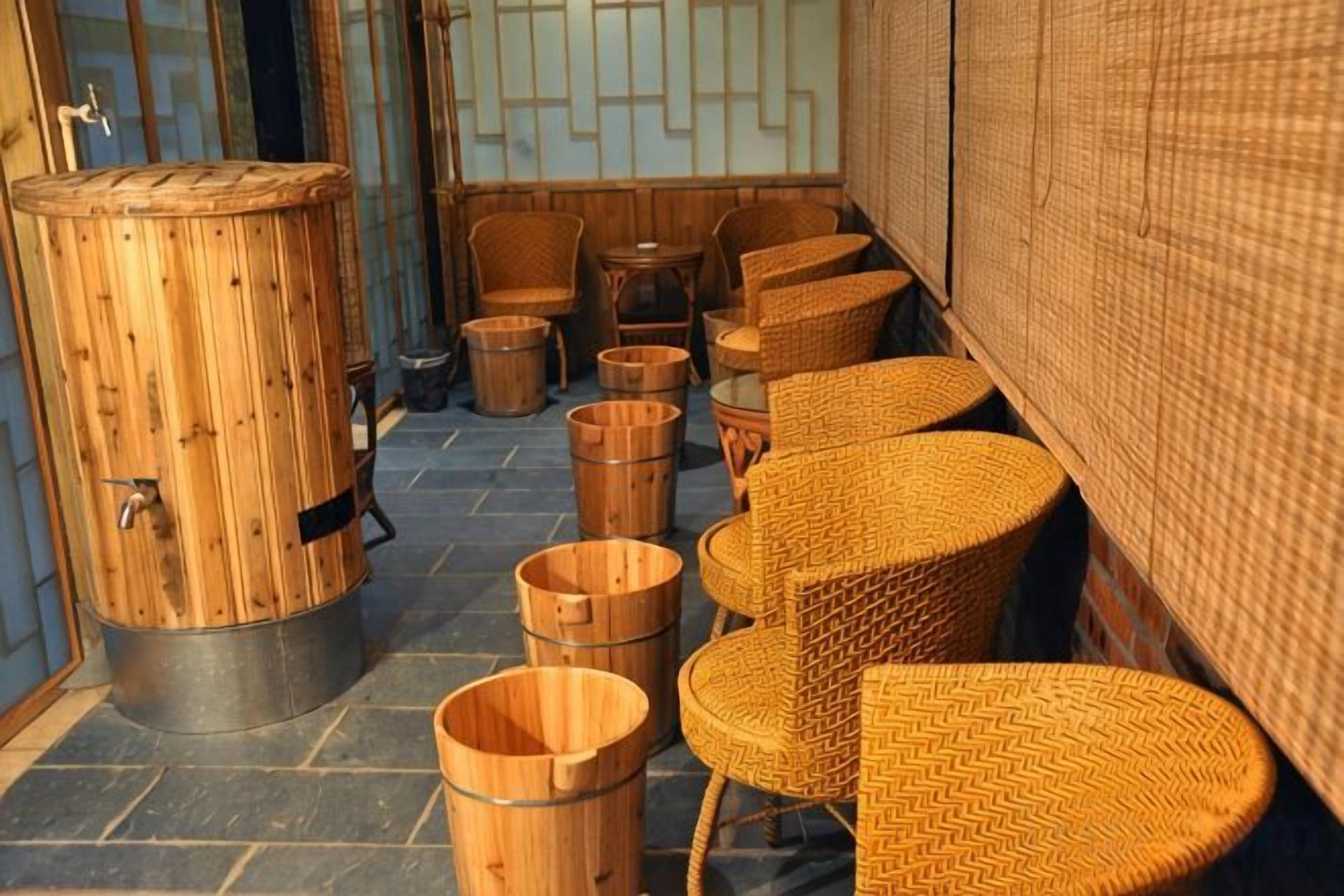 A traditional Japanese-style room with tatami mats, wooden furniture, and a large wooden bucket.