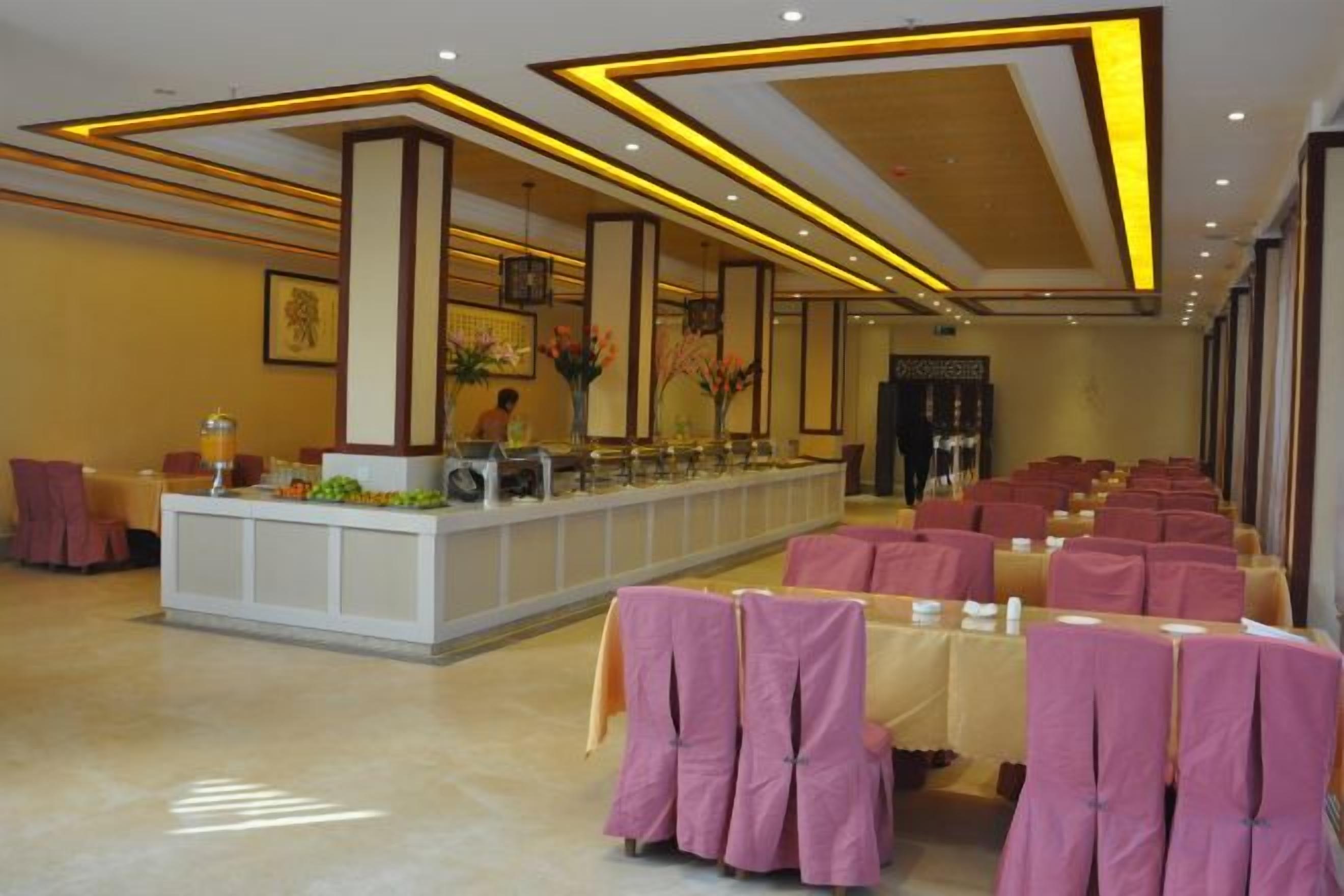 A hotel lobby with a reception desk, seating area, and a large window.