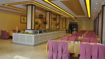 A hotel lobby with a reception desk, seating area, and a large window.