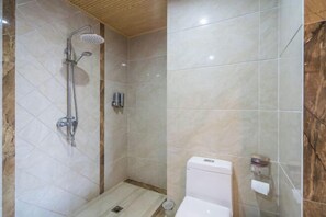 A modern bathroom with a shower, toilet, and a marble-tiled wall.