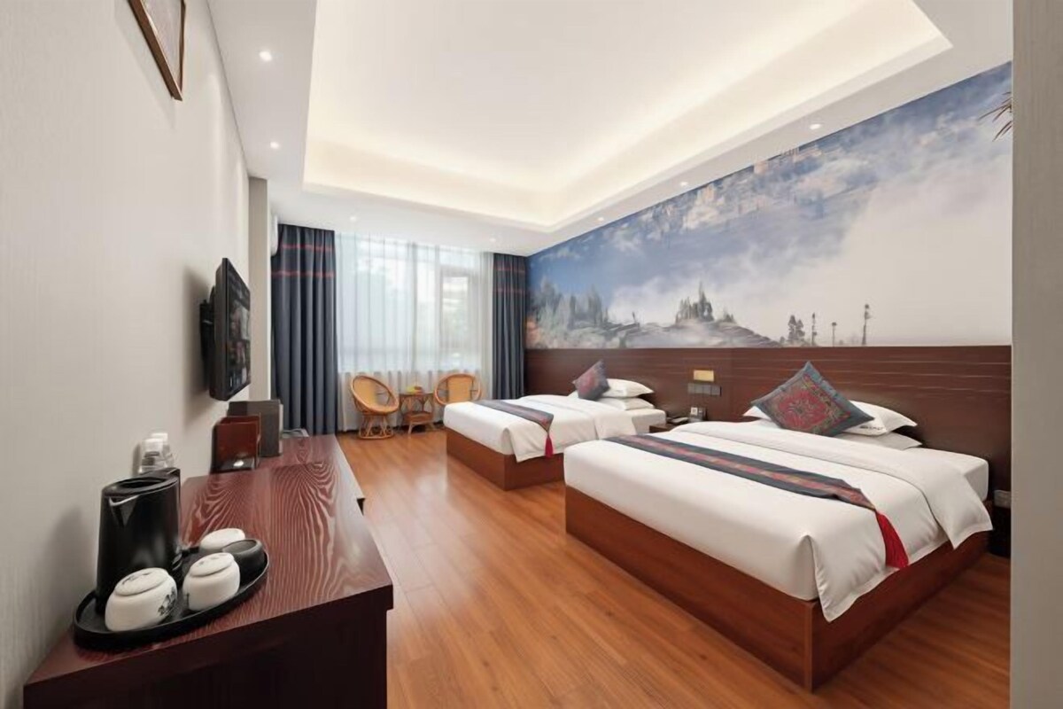 Habitación de hotel con una cama grande, un escritorio con una silla, un televisor y un cuadro en la pared.