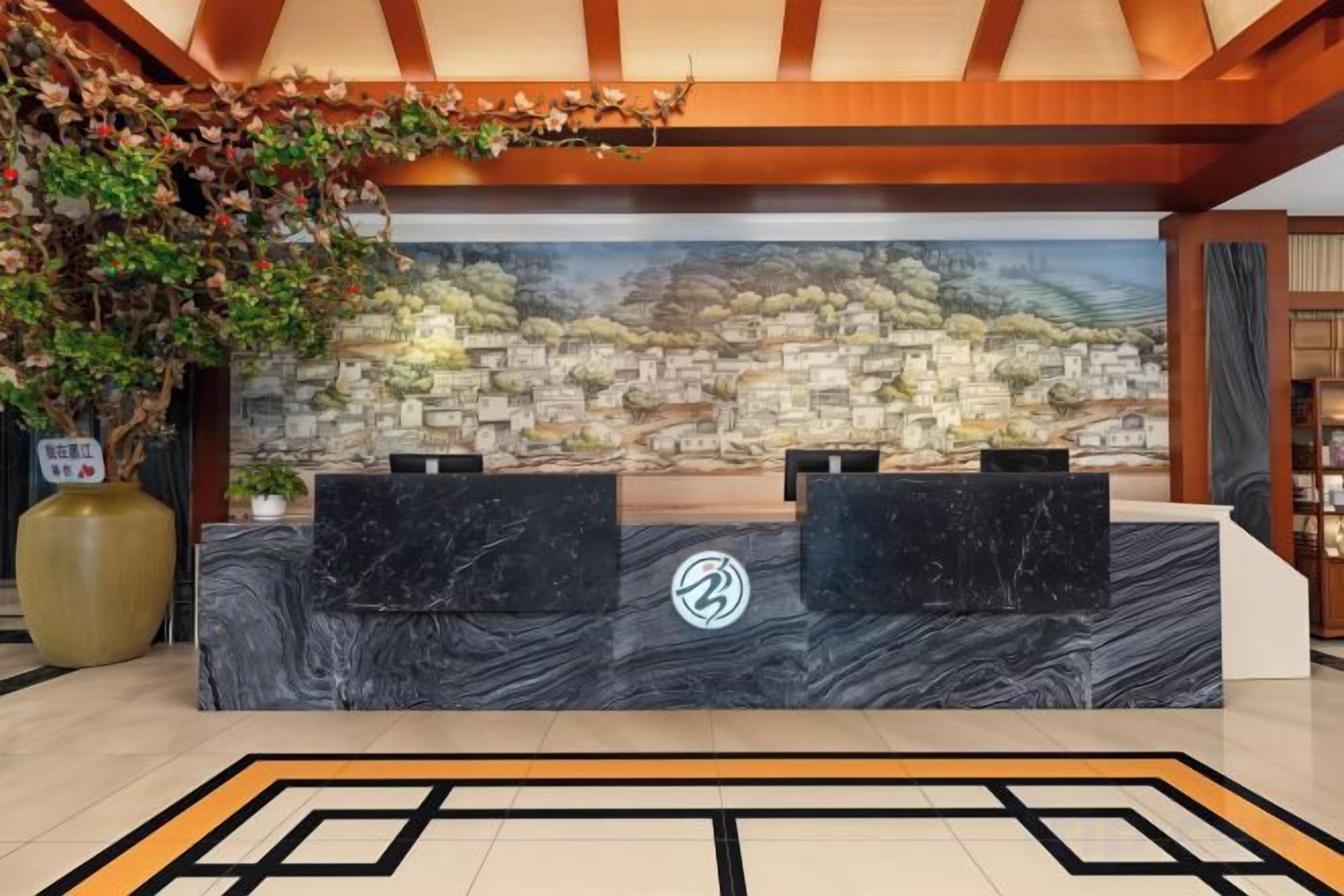 A reception desk with a marble top, two black chairs, and a logo in the center.