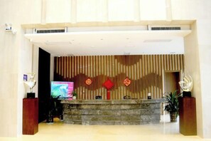 A reception area with a reception desk, a television, and decorative elements. - Xenp Xangh Xedt Lail Hotel (Congjiang)