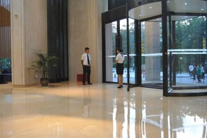 A lobby with a glass door entrance, a potted plant, and a reflective floor. - Xenp Xangh Xedt Lail Hotel (Congjiang)