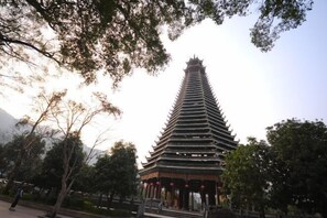 A pagoda-style building with multiple tiers, surrounded by trees and a clear sky. - Xenp Xangh Xedt Lail Hotel (Congjiang)