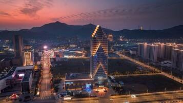 A cityscape with a prominent triangular building, a highway, and surrounding urban infrastructure.