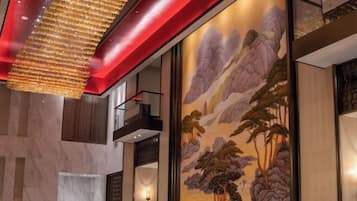 A modern interior with a mural, a red ceiling, and a hanging light fixture.