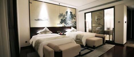 A modern hotel room with two beds, a large artwork on the wall, and a sliding glass door leading to a balcony.