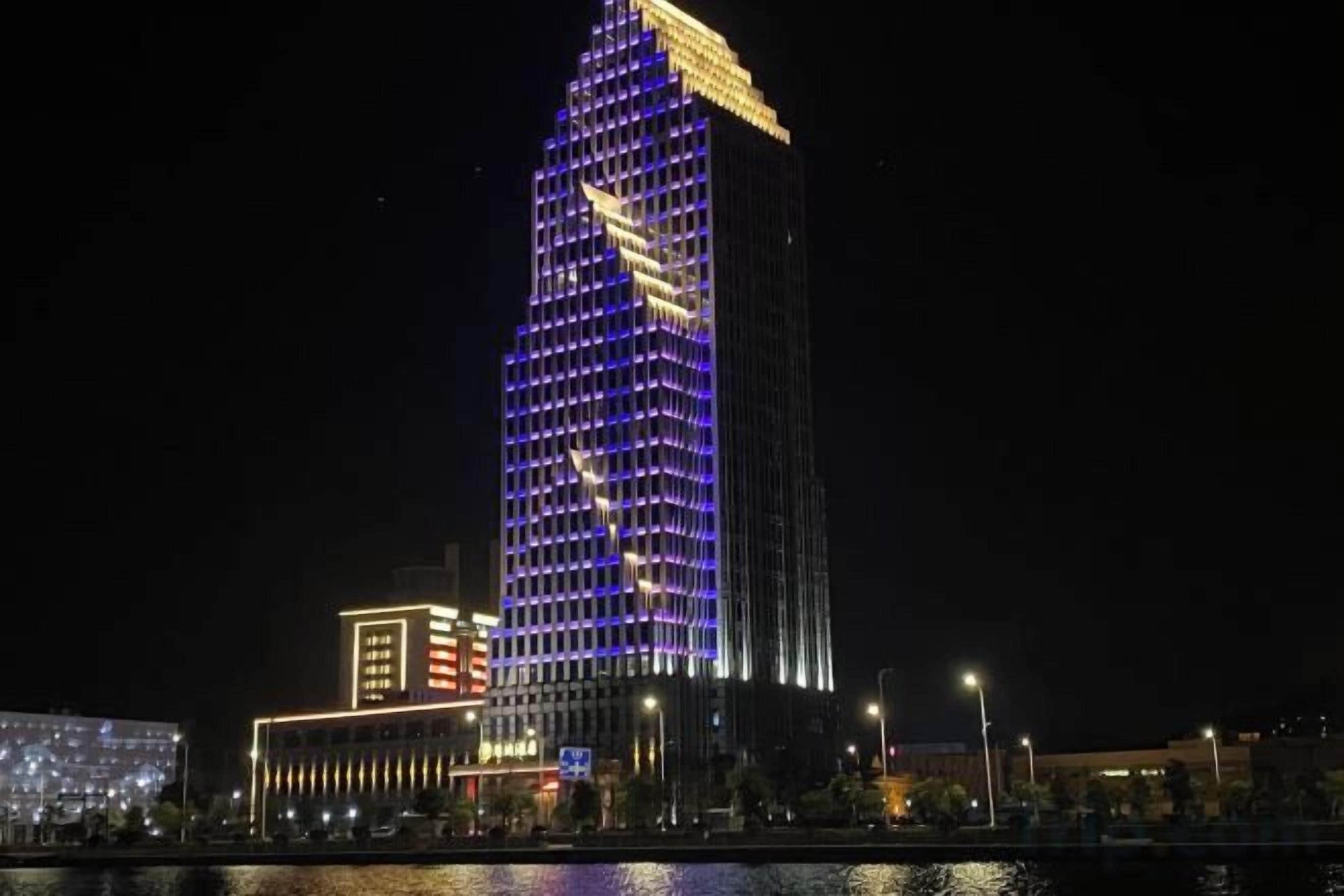 A high-rise building with illuminated windows at night.