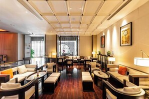 A spacious lobby with multiple seating areas, a large window, and a decorative wall. - Gangcheng Hotel (Zhoushan)