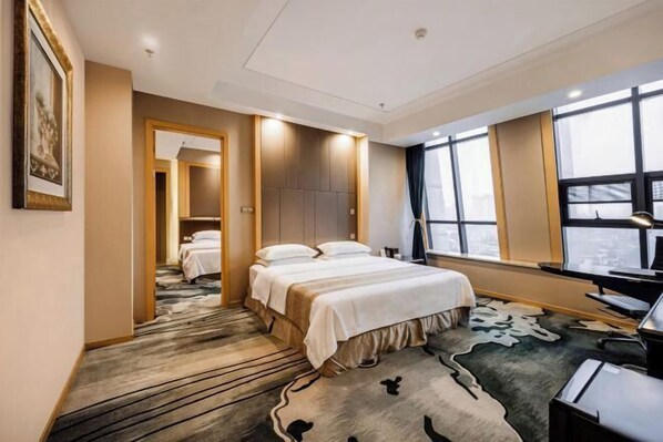 A hotel room with a large bed, a desk with a computer, and a view of the city through large windows. - Jiasheng Jinling Hotel (Nanjing)