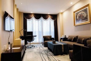 A hotel room with a piano, a sofa, a table, and a large window with curtains. - Jiasheng Jinling Hotel (Nanjing)