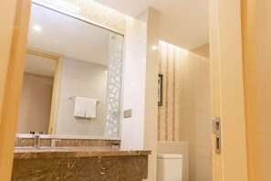 A bathroom with a marble countertop, a toilet, and a mirror. - Jiasheng Jinling Hotel (Nanjing)
