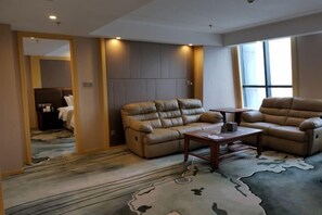 A modern living room with leather sofas, a coffee table, and a patterned rug. - Jiasheng Jinling Hotel (Nanjing)