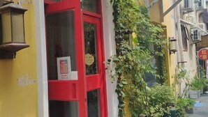 Ein Gebäude mit roter Tür und einem Schild mit chinesischen Schriftzeichen.