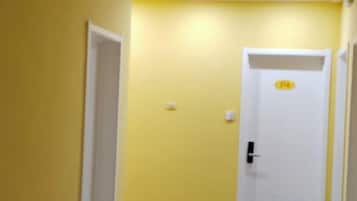 Un pasillo estrecho con una puerta blanca al final.