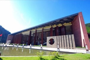 A modern building with a reflective water feature in front.