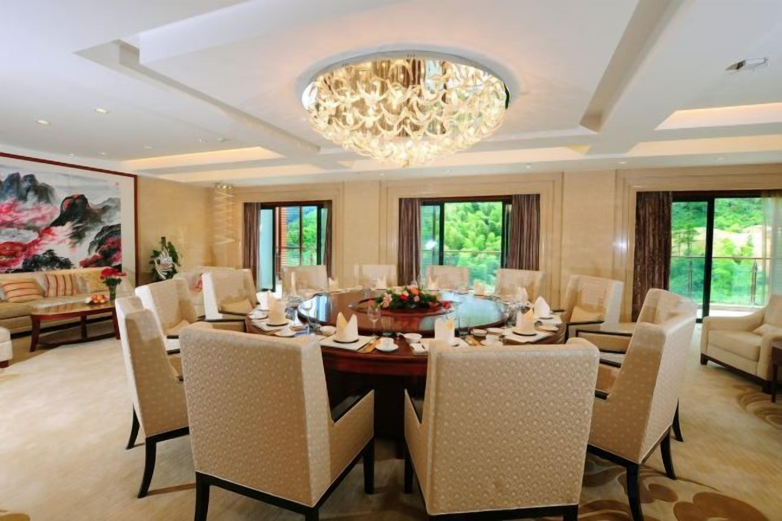 Un espace repas comprenant une table ronde, des chaises et un lustre.