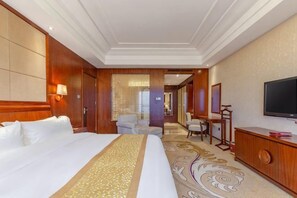 A hotel room with a large bed, a television, a desk, and a chair. - Zhongxin Convention Center (Jinggangshan City)