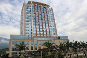 A multi-story hotel with a modern design, featuring a prominent central tower and a flat facade with large windows. - an Ran Hotel (Zhenkang)