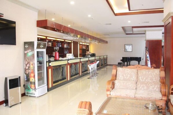 A hotel lobby with a bar area, seating, and a piano. - an Ran Hotel (Zhenkang)