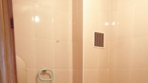 Ein kleines Badezimmer mit Toilette, Waschbecken, Spiegel, Mülleimer und Toilettenpapierhalter.