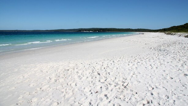 A wide, white sandy beach with clear blue water and a distant shoreline. - Serenity by the Bay - Whole House in Vincentia, Jervis Bay (Vincentia)