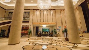A lobby with large columns, a chandelier, and a reception desk. - Tianbaolong Hotel (Fusui)