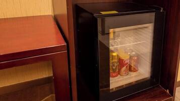 Geladeira compacta com porta de vidro, contendo bebidas e acompanhamentos.