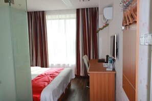 A hotel room with a bed, a desk, a chair, a mirror, and a wardrobe. - Shankee Express Hotel (Meizhou Lijiangwan) (Meizhou)