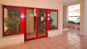 Ein Hotel mit rotem Eingangsbereich, einem Rauchverbot-Schild und einem gefliesten Boden.