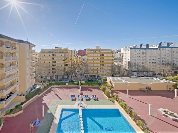 A pool area with a clear blue pool, lounge chairs, and a view of surrounding buildings. - Apolo VII by Interhome (Calpe/Calp)